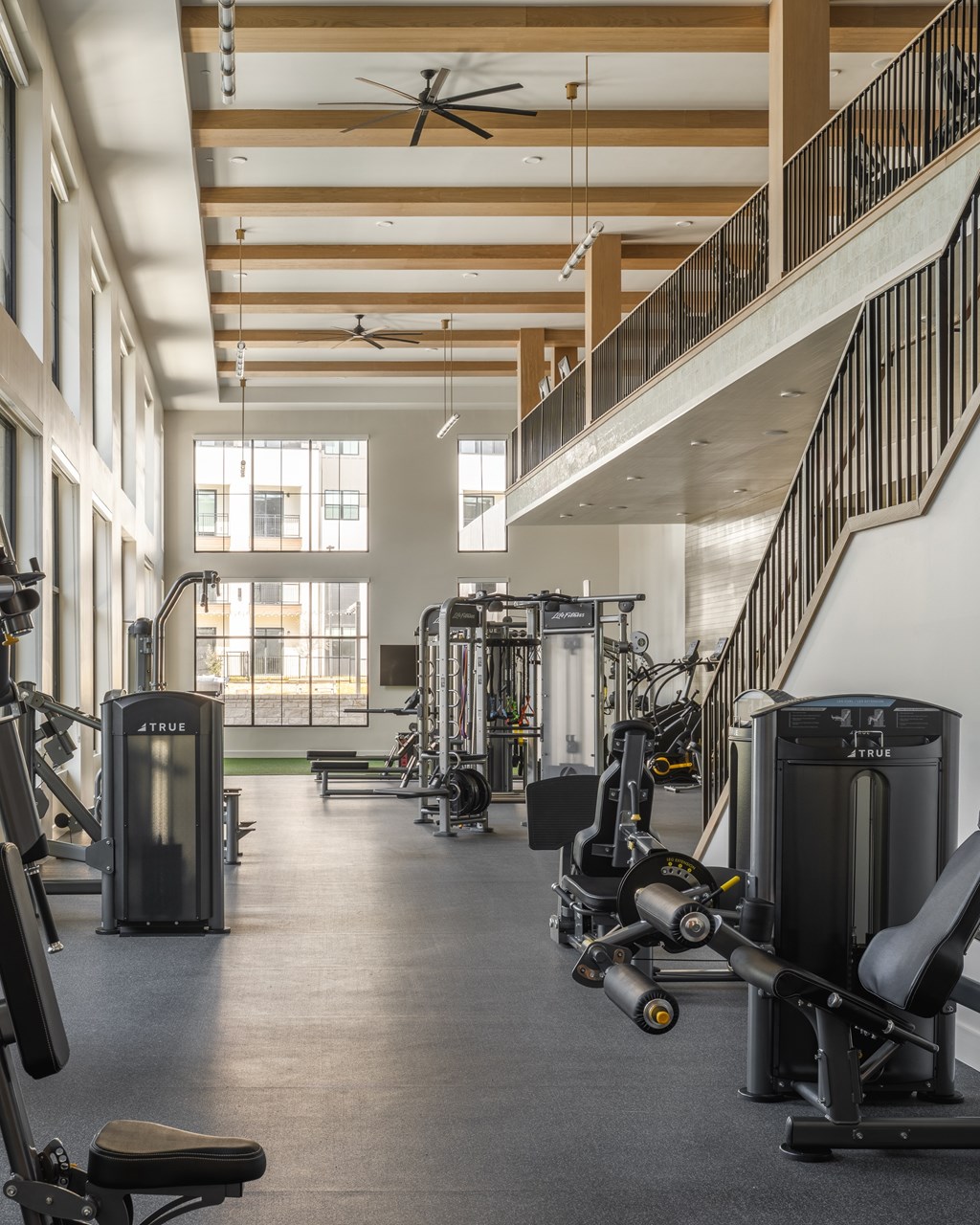 A gym with a variety of equipment including weights and cardio machines.